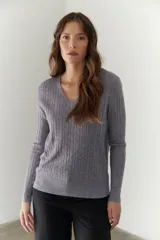Sweater de punto marrón con escote en V y mangas largas.