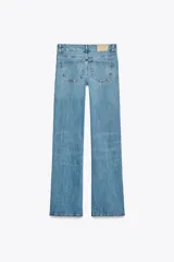 Jeans de tiro bajo con trabillas y cinco bolsillos. Bajo acampanado desde la rodilla. Cierre frontal con cremallera y botón metálico.
