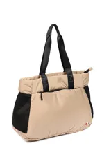 Bolso color beige con asas de cinta negra, bolsillos laterales de red negra y cierre superior con cremallera.