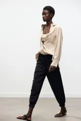 Pantalón jogger marrón de tiro alto con cintura elástica ajustable con cordones, bolsillos delanteros y puños elásticos en los tobillos.