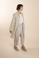 Camisa larga color crema con rayas verticales finas en gris, con botones dorados y bolsillo plaque en la delantera.