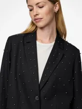 Blazer negro con cuello clásico, cierre de botones y bolsillos frontales. Tiene tachas plateadas en el frente y las mangas.