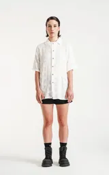 Camisa blanca con bordado de flores blancas, de manga corta y corte recto.