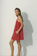 Vestido corto rojo, sin mangas, con escote en V y corte holgado. Presenta bolsillos laterales.