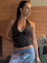 Top negro con cuello halter y espalda descubierta, con apliques de tachas plateadas.