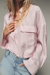 Camisa blanca de modal con cuello solapa, manga larga con puños abotonados, cierre frontal con botones y dos bolsillos con solapa en el pecho.