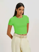 Blusa cropped de tela acanalada color verde neón, con cuello redondo y mangas cortas.