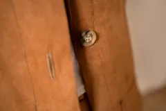 Chaqueta color marrón con cuello de pana color chocolate, con bolsillos grandes y botones al frente.