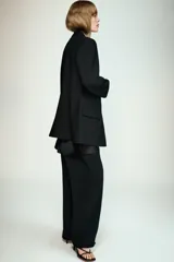 Blazer negro de manga larga con cuello solapa y cierre frontal de un solo botón. Presenta bolsillos delanteros con solapas.