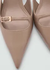 Zapato destalonado color beige con punta fina, tacón kitten y hebilla decorativa.