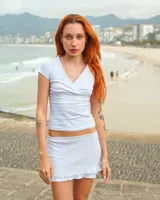 Top blanco de algodón con escote cruzado en V y mangas cortas.