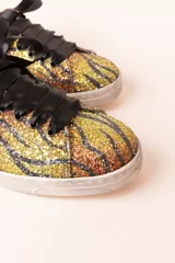 Zapatillas deportivas con estampado de tigre, cordones de raso negros y detalles en ante negro en el talón.