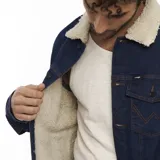 Campera de jean azul con forro de sherpa color crema en el cuello y el interior. Tiene bolsillos con solapa en el pecho, bolsillos laterales y cierre con botones.