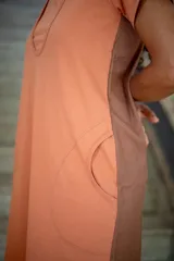 Vestido corto color salmón con paneles laterales en marrón. Cuenta con doble escote para facilitar la lactancia, bolsillos laterales y bajos redondeados.