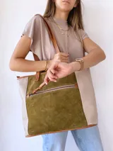 Bolso tipo tote de cuero color verde oliva con laterales de cuero texturizado color beige y manijas de cuero color marrón.