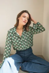 Camisa de manga larga con cuello camisero y botones frontales. Estampado con motivos geométricos en tonos verde, celeste y beige.