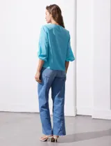 Blusa de gasa color blanco con estampado de hojas verdes, de mangas 3/4 abullonadas con puños elásticos.