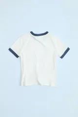 Camiseta blanca de algodón con cuello redondo y mangas cortas con ribete azul marino en cuello y mangas.