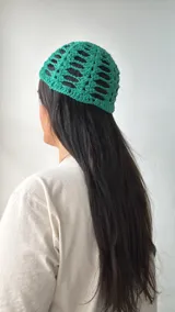 Gorro de crochet color verde esmeralda con diseño calado.