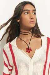 Collar con cordón negro y dije de flor acrílica color rojo.