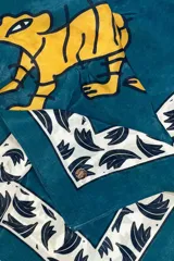 Pañuelo cuadrado de 100x100 cm, con estampado de un tigre amarillo sobre fondo azul y borde con diseño de hojas en blanco y negro.