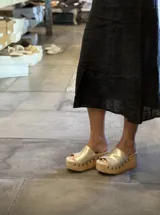 Sandalias con plataforma de madera y capellada dorada con detalle de tachas.