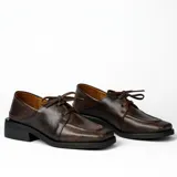 Zapato acordonado de cuero vacuno color marrón oscuro, con suela de goma, horma cuadrada y tacón bajo.