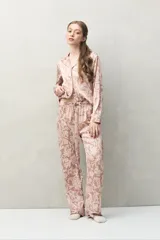 Pantalón de pijama color rosado con estampado floral en blanco, de fit relajado, cintura elastizada y calce fluido.
