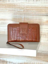 Billetera de dama color marrón con textura croco, confeccionada en 100% cuero, con compartimentos para tarjetas y billetes.