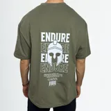 Remera verde militar de algodón con estampado en la espalda con la palabra "ENDURE" repetida y un casco espartano. Incluye una frase motivacional y el logo "GAINS."