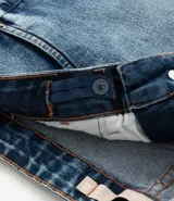 Short de jean azul oscuro, tiro alto, con bajo doblado y trabillas en la cintura.