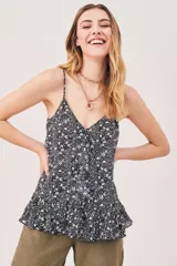 Top con estampado floral en blanco y negro, breteles finos y corte holgado con volados en el ruedo. Escote en V.