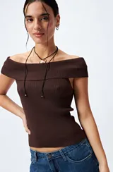 Top tejido color blanco con escote bardot que deja los hombros al descubierto y punto acanalado.