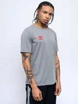 Remera deportiva negra de poliéster con logo de Umbro estampado en blanco en el pecho.