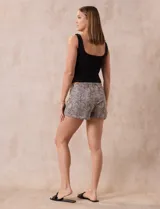 Conjunto de pijama de dos piezas marca René Rofé, compuesto por un top negro de breteles finos y un short con estampado animal print en tonos beige y negro, con cintura elastizada y cordón de ajuste.