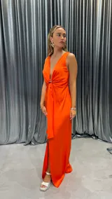 Vestido largo color naranja, sin mangas, con escote en V y abertura en la pierna.
