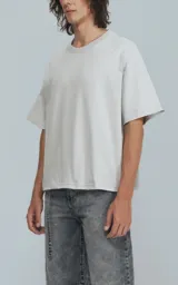 Remera manga corta gris, cuello redondo, de calce boxy fit, confeccionada en textil 100% algodón.