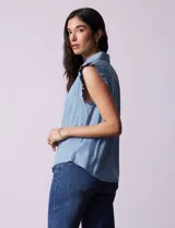 Blusa celeste sin mangas en tencel, marca Zac & Rachel. Cuello con solapa y abertura con botones. Mangas con frunces.
