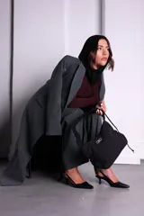 Bolso negro de nylon con textura sutil y manija fruncida.