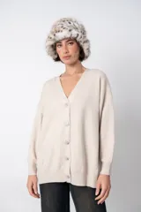 Cardigan beige con escote en V y botones con forma de rombo.