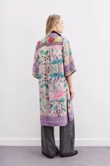 Kimono largo hasta la rodilla, de mangas 3/4 y calce amplio con tajos laterales. Diseño estampado con motivos florales y guardas.