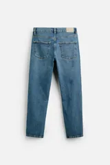 Pantalón de jean azul oscuro, corte slim fit, tiro medio, cinco bolsillos, tejido elástico y efecto lavado.