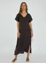 Vestido marrón de lino, corte recto, largo midi, con cuello en V y mangas cortas. Presenta aberturas laterales en el ruedo.