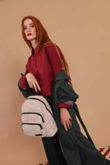 Mochila funcional color beige con detalles en negro, que incluye dos compartimentos con cierre y un bolsillo frontal para fácil acceso.