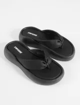 Sandalias negras de cuero sintético con base moldeada y tira ancha.