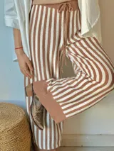 Pantalón de punto a rayas verticales color camel y crudo, con cintura alta y cordón ajustable.