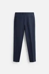 Pantalón de vestir azul marino, de corte slim fit, con bolsillos laterales y traseros de doble vivo con botón. Se ajusta a la cintura con cierre frontal con cremallera y botón.