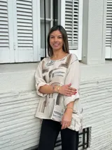 Blusa beige de lino con estampado abstracto en tonos marrones y grises, de corte holgado, manga 3/4 y bolsillos delanteros.