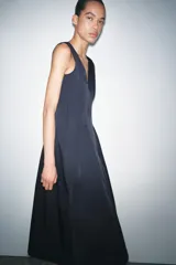 Vestido midi azul marino confeccionado en hilatura con algodón. Escote pico y tirantes anchos. Bajo evasé. Cierre frontal con cremallera metálica.