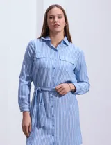 Vestido camisero corto a rayas verticales color beige, con cuello con solapa, abertura central con botones, bolsillos aplicados en el pecho y lazo de ajuste en la cintura.